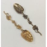 A matched pair of silver gilt teaspoons with leaf