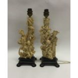 A pair of Chinese resin lamps on wooden bases. Est