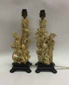 A pair of Chinese resin lamps on wooden bases. Est