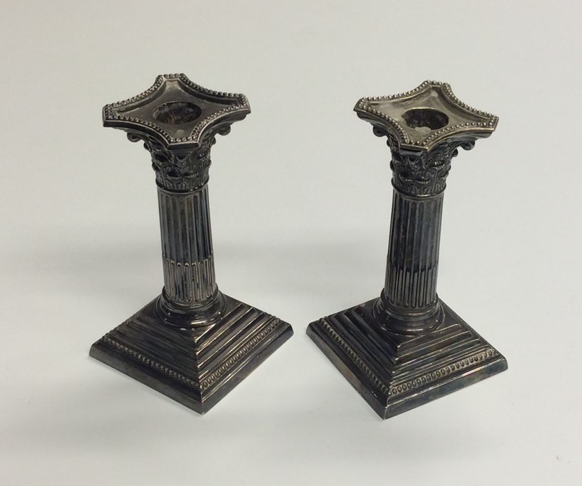A pair of Corinthian column candlesticks. Est. £30