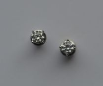 A pair of cased diamond single stone ear studs in