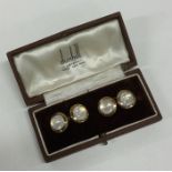 A pair of gold and cabochon stone cufflinks contai