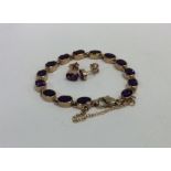 A 9 carat amethyst bracelet with safety chain toge