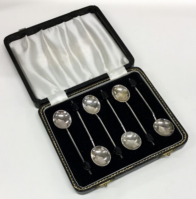 A cased set of six silver bean top coffee spoons.