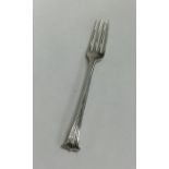 A Georgian silver fork with tapering scroll handle