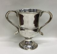 A Georgian silver two handled loving cup on spread