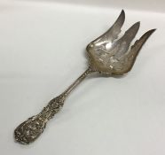 A large pierced silver fork cast with flowers and