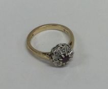 A ruby and diamond circular cluster ring in 18 car