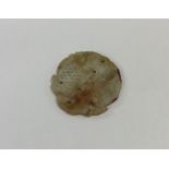 A carved jade circular disc. Approx. 17 grams. Est