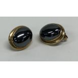 A pair of gold mounted earrings set with large cen