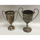 Two silver two handled trophy cups on spreading ba