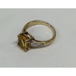 A diamond and yellow stone ring in claw mount. App