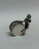 An unusual silver miniature cherub pounding a drum