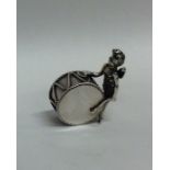 An unusual silver miniature cherub pounding a drum
