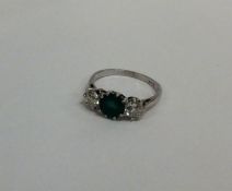 An attractive emerald and diamond three stone ring