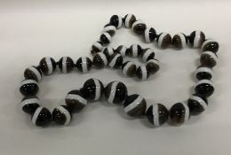A large tapering string of banded agate beads. App