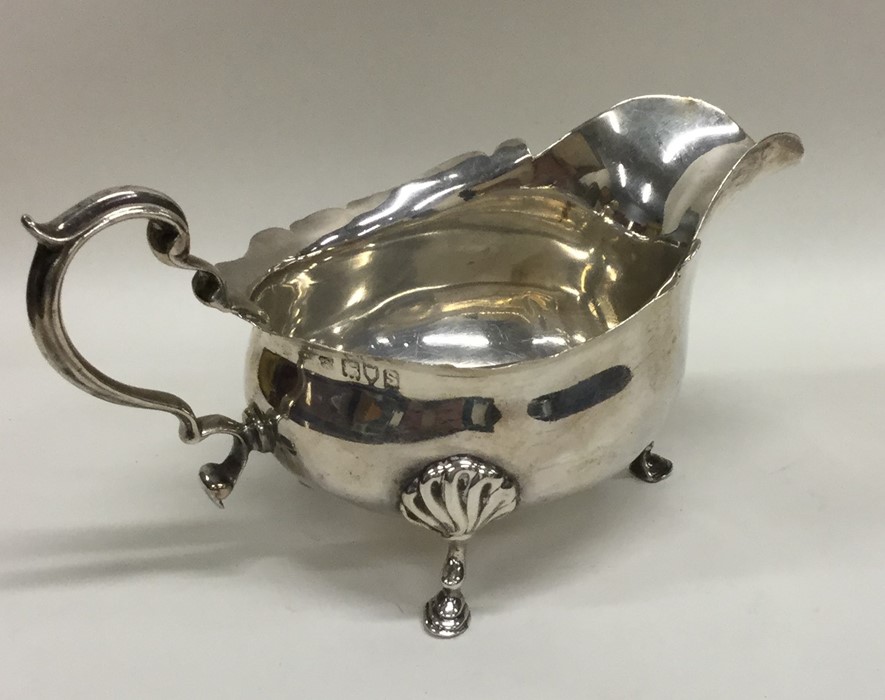 An Edwardian silver sauce boat with scroll feet. L