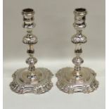 A good pair of cast silver candlesticks on spreadi