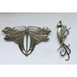 A silver dragonfly brooch together with one other.