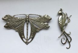 A silver dragonfly brooch together with one other.