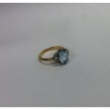 An aquamarine and diamond cluster ring in gold and