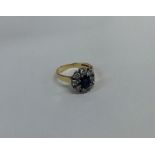 A circular sapphire and diamond cluster ring in 18