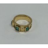 An emerald and diamond tapering ring in 18 carat g