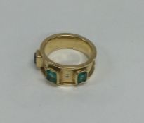 An emerald and diamond tapering ring in 18 carat g