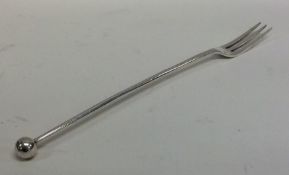 A silver tapering pickle fork with ball terminal.