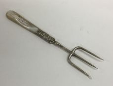 A silver and MOP bread fork embossed with flowers