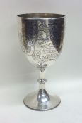 A heavy engraved silver goblet on spreading base.