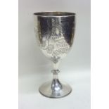 A heavy engraved silver goblet on spreading base.