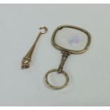 A small gold mounted button hook with pearl border