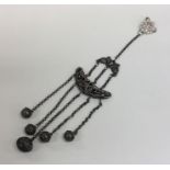 An Edwardian silver rattle on suspension chains. A