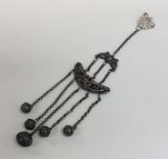 An Edwardian silver rattle on suspension chains. A