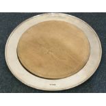 A large circular silver bread board with wooden in
