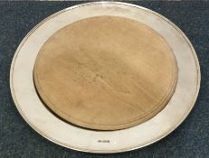 A large circular silver bread board with wooden in