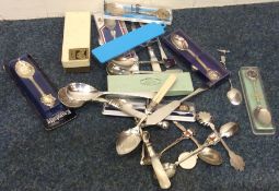 A large collection of old plated souvenir spoons.