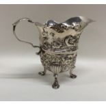 A George II Irish silver cream jug profusely decor