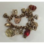 A heavy 9 carat multi charm bracelet with heart sh