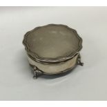 A circular hinged top silver ring box with fitted