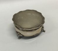 A circular hinged top silver ring box with fitted