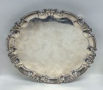 A circular silver salver with pie crust rim to scr