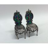 A pair of plique-à-jour silver miniature chairs wi