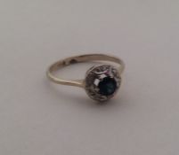 A sapphire and diamond circular cluster ring. Appr