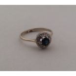 A sapphire and diamond circular cluster ring. Appr