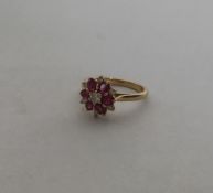An attractive 18 carat gold ruby and diamond daisy