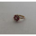 An attractive 18 carat gold ruby and diamond daisy