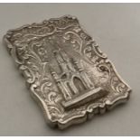 A silver card case with Scott Memorial in relief.