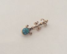 A stylish turquoise brooch with scroll mounts. App